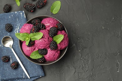 Photo of Delicious blackberry sorbet with fresh berries in bowl and spoon on gray textured table, flat lay. Space for text