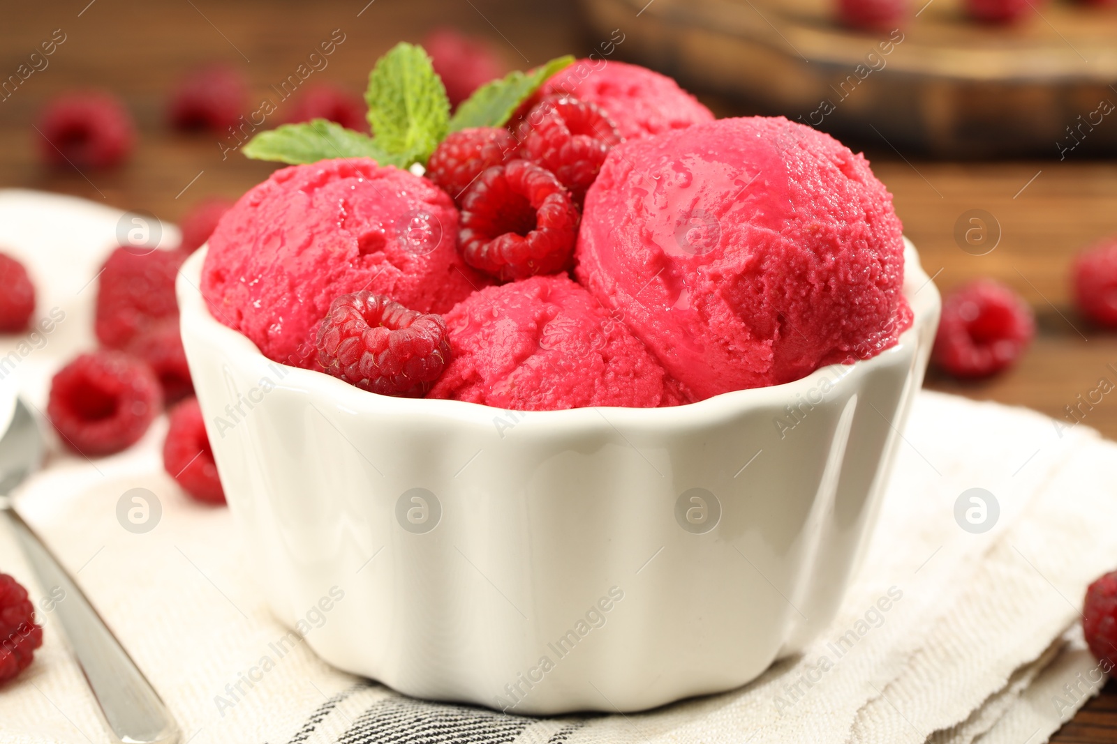 Photo of Delicious raspberry sorbet, fresh berries and mint in bowl on table, closeup