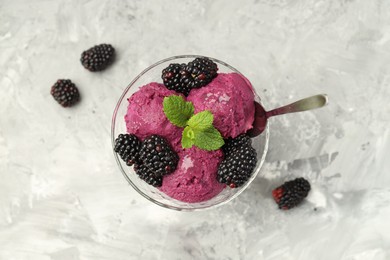 Photo of Delicious blackberry sorbet, fresh berries and mint in glass dessert bowl served on gray textured table, top view