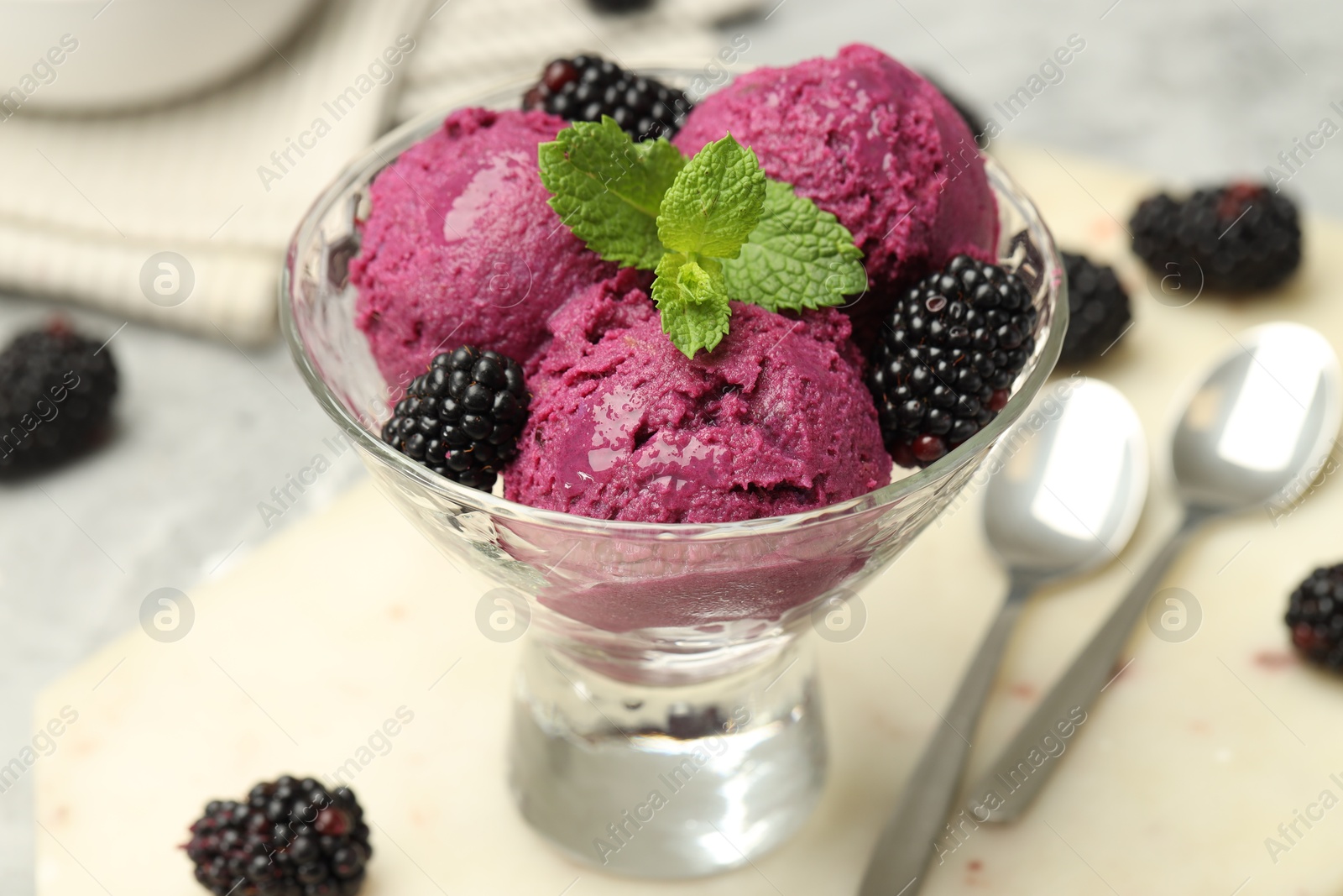 Photo of Delicious blackberry sorbet, fresh berries and mint in glass dessert bowl on table, closeup