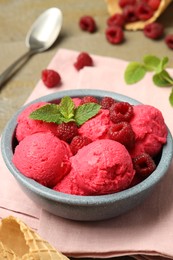 Photo of Delicious raspberry sorbet, fresh berries and mint in bowl on light table