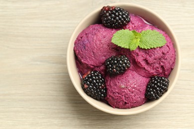 Photo of Delicious blackberry sorbet, fresh berries and mint in bowl on wooden table, top view