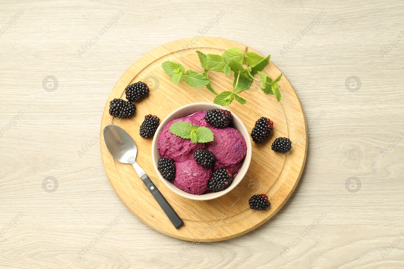 Photo of Delicious blackberry sorbet with fresh berries in bowl and spoon on table, top view