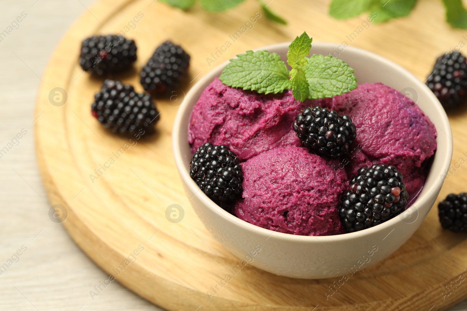 Photo of Delicious blackberry sorbet, fresh berries and mint in bowl on table, closeup