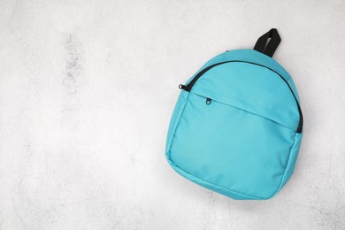 Photo of Blue school backpack on light grey table, top view. Space for text