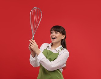 Happy pastry chef with big whisk on red background