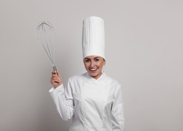 Image of Happy pastry chef with big whisk on light grey background