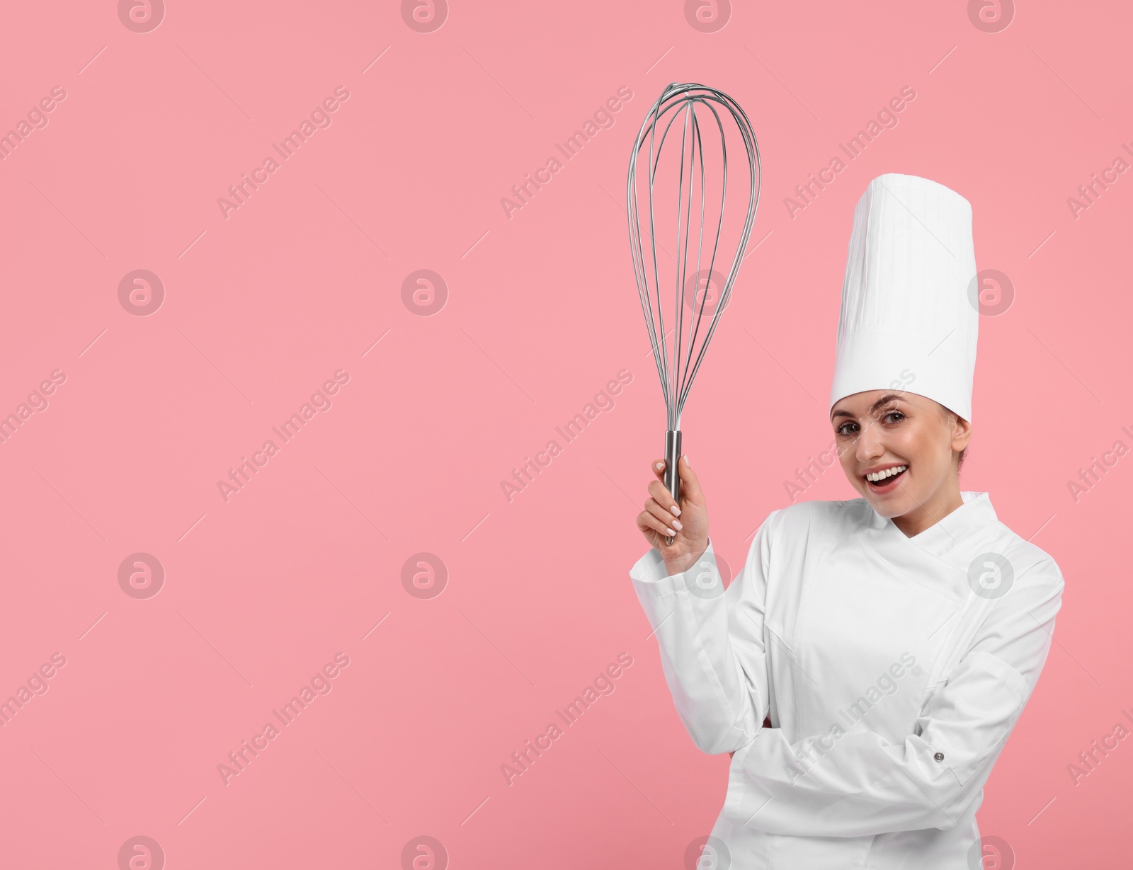 Image of Happy pastry chef with big whisk on pink background. Space for text