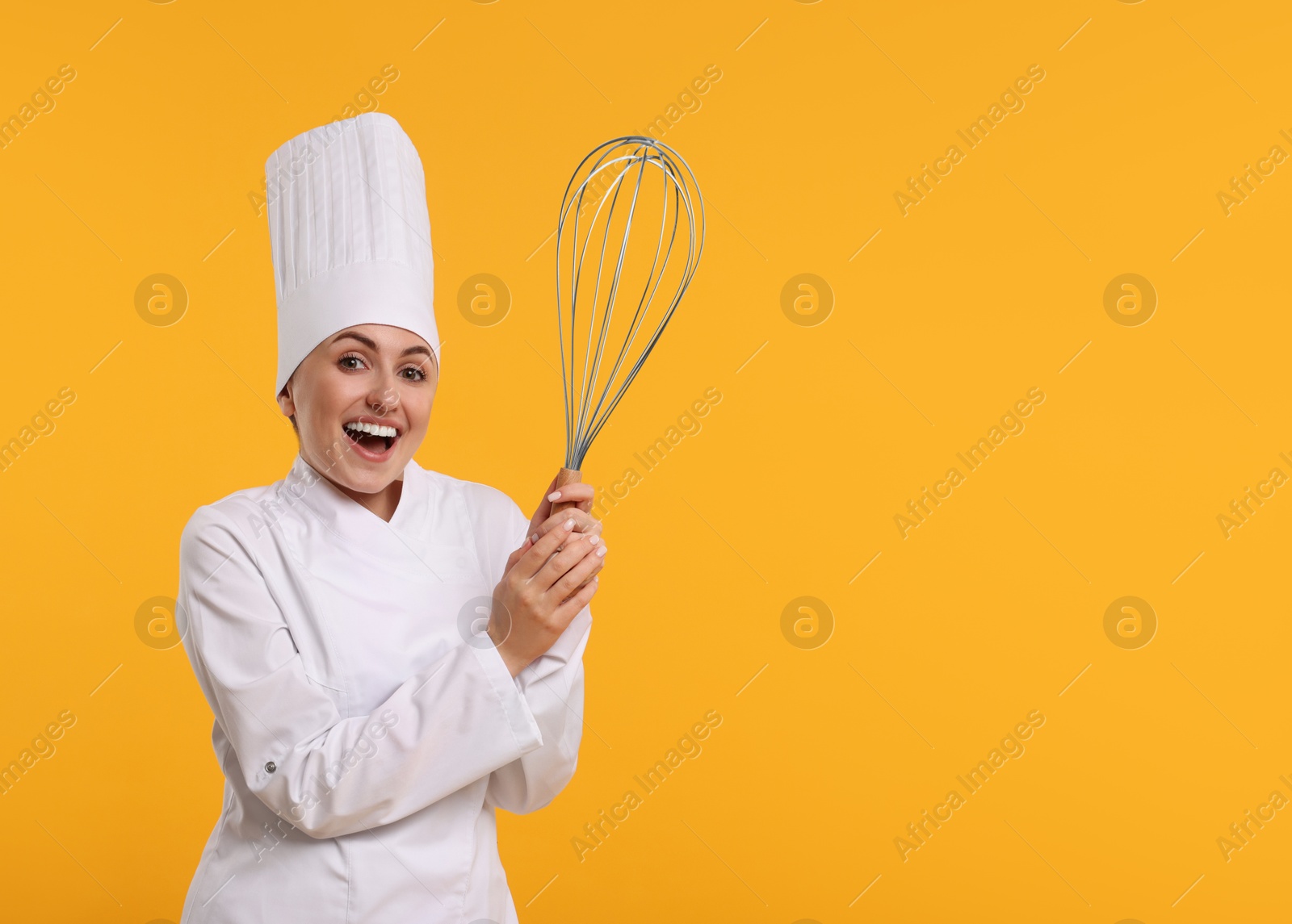 Image of Happy pastry chef with big whisk on orange background. Space for text