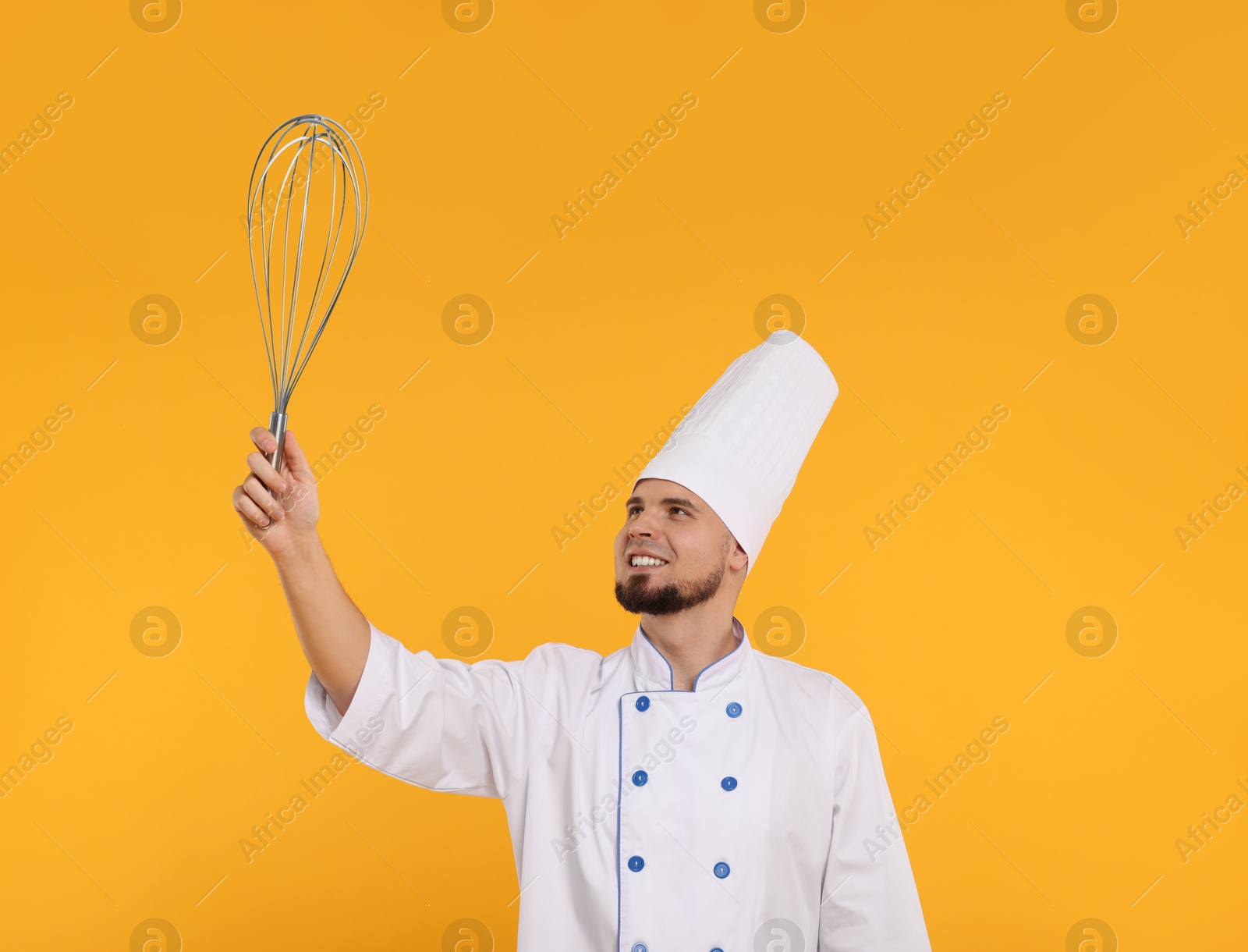 Image of Happy pastry chef with big whisk on orange background