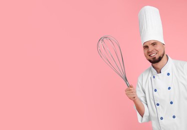 Happy pastry chef with big whisk on pink background. Space for text