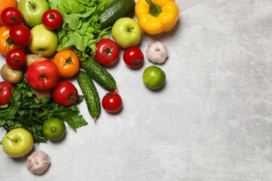 Photo of Healthy vegetarian food. Different vegetables and apples on grey textured table, flat lay. Space for text