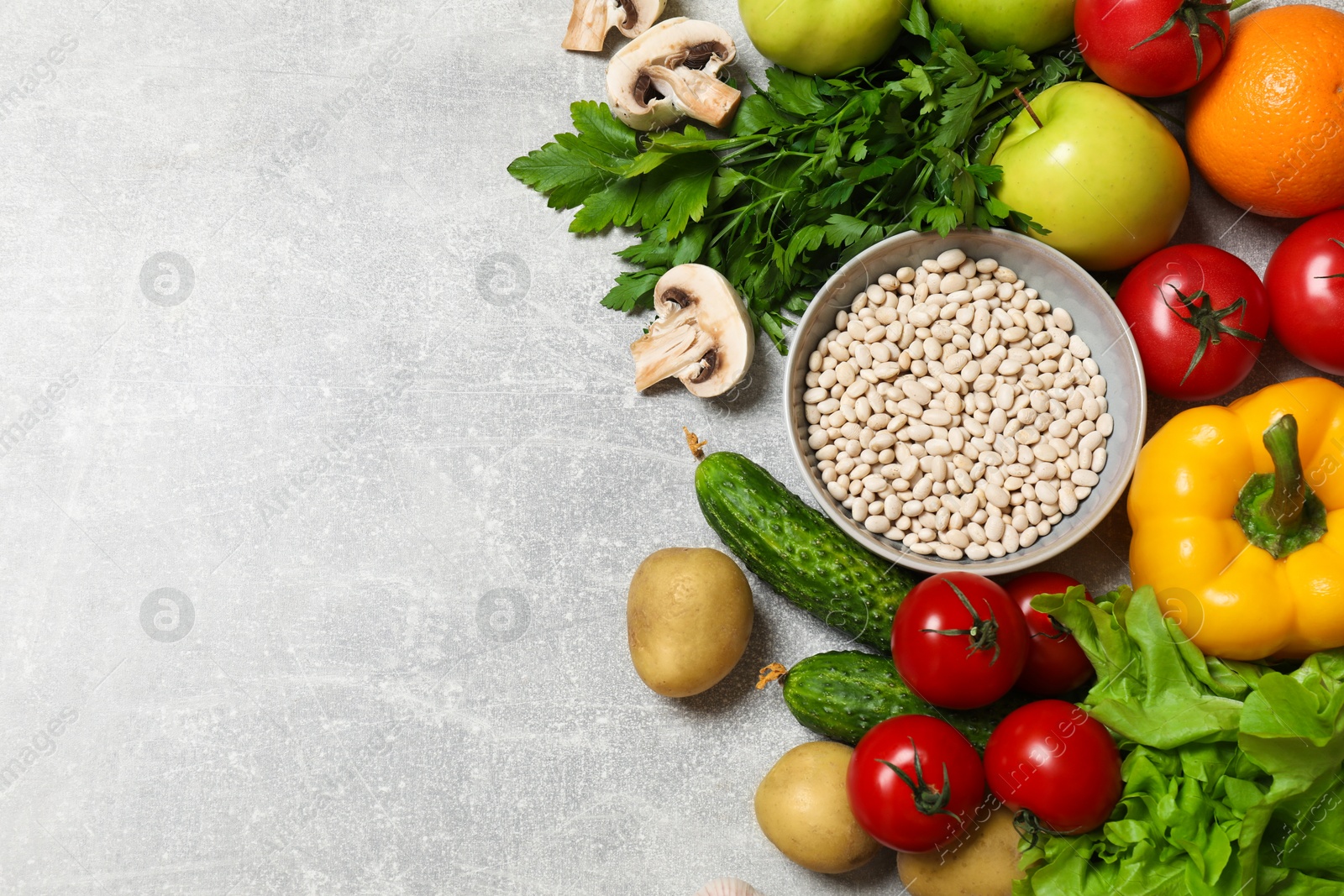 Photo of Healthy vegetarian food. Different vegetables, lentils and apples on grey textured table, flat lay. Space for text