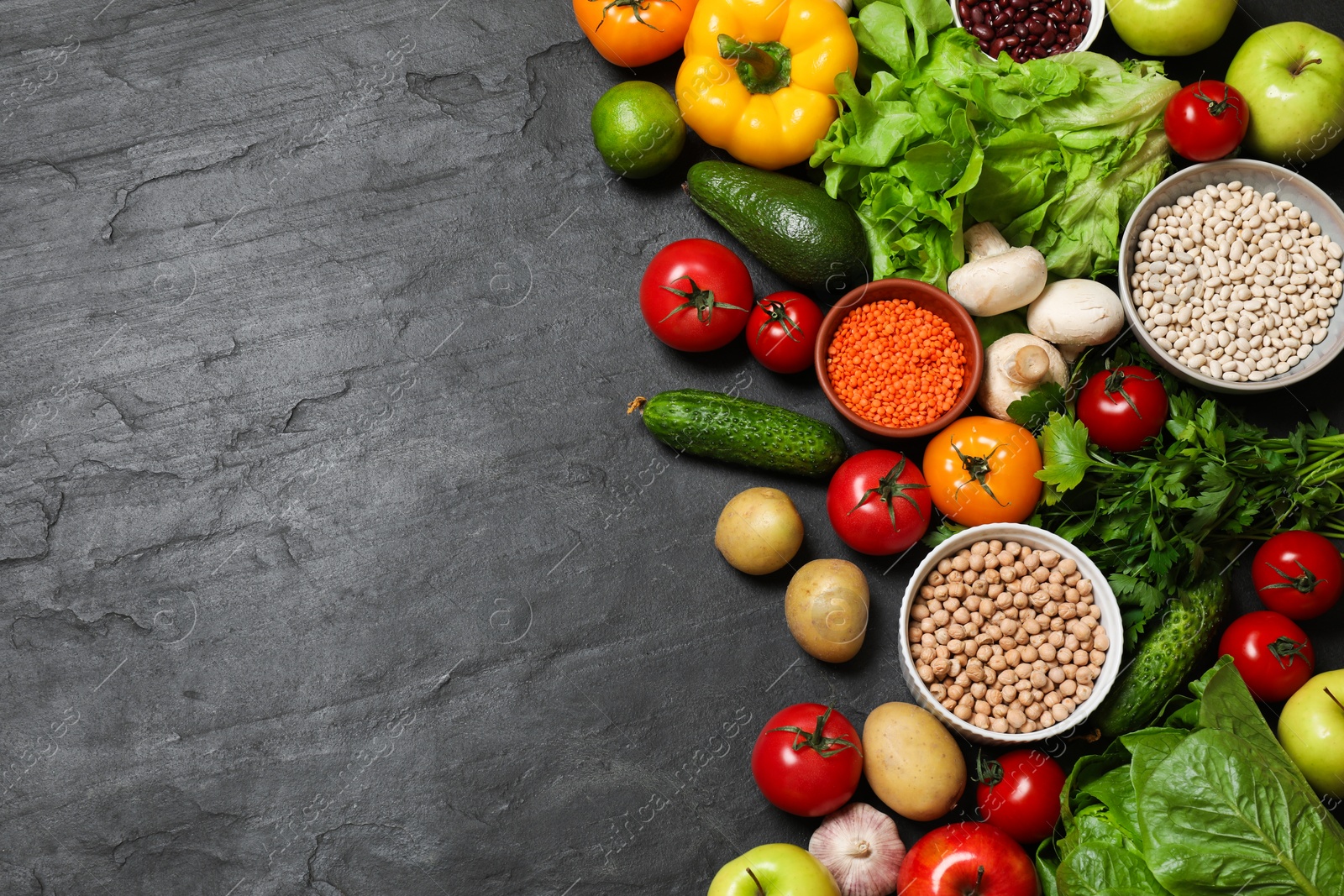 Photo of Healthy vegetarian food. Different vegetables, lentils and apples on dark textured table, flat lay. Space for text