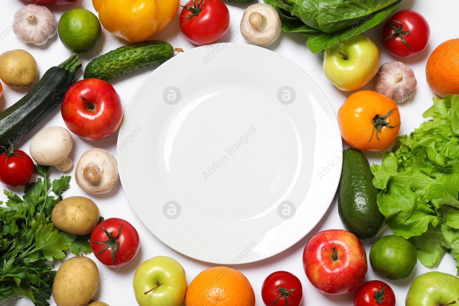 Photo of Healthy vegetarian food. Empty plate surrounded by different vegetables, mushrooms and fruits on white background, flat lay