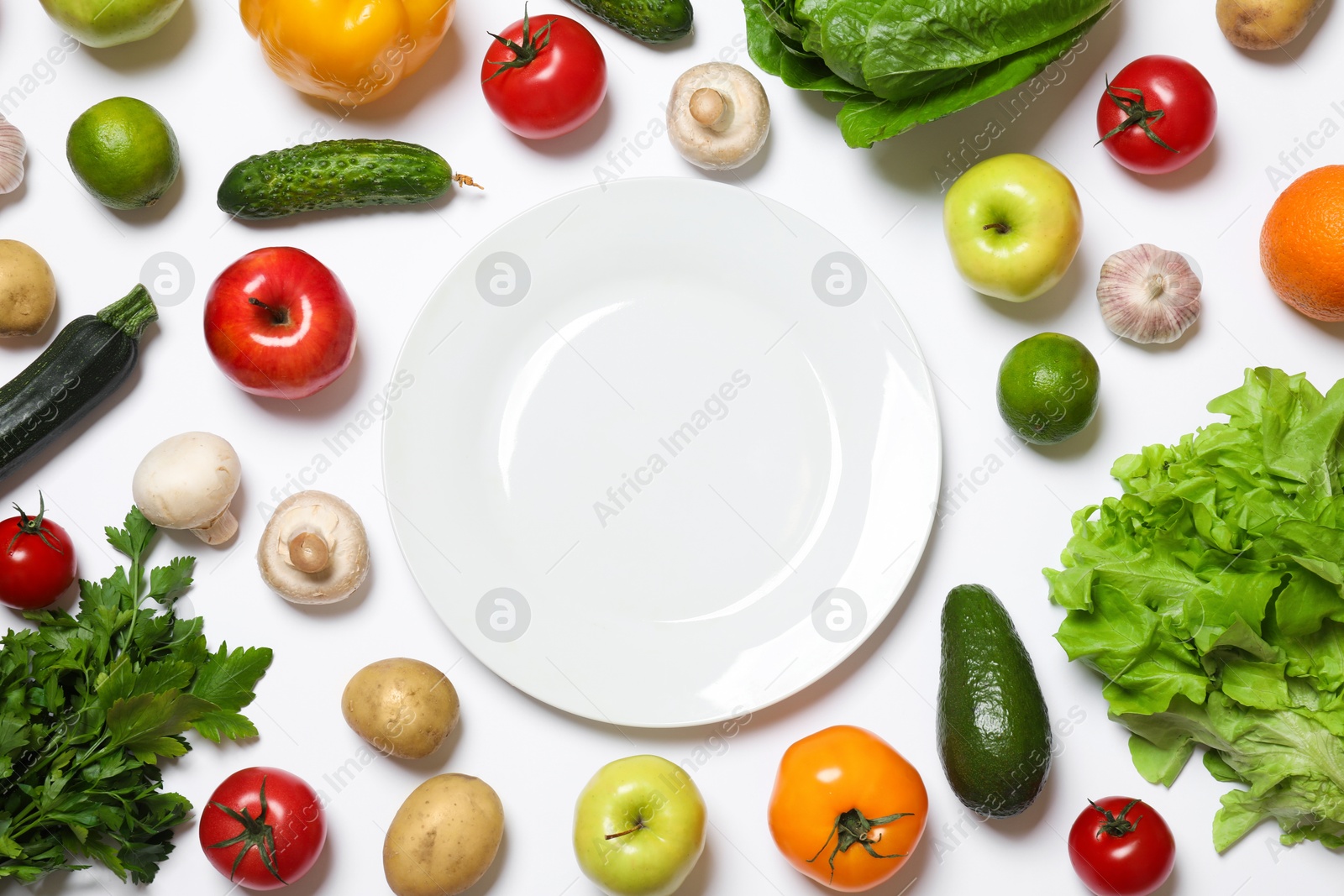 Photo of Healthy vegetarian food. Empty plate surrounded by different vegetables, mushrooms and fruits on white background, flat lay