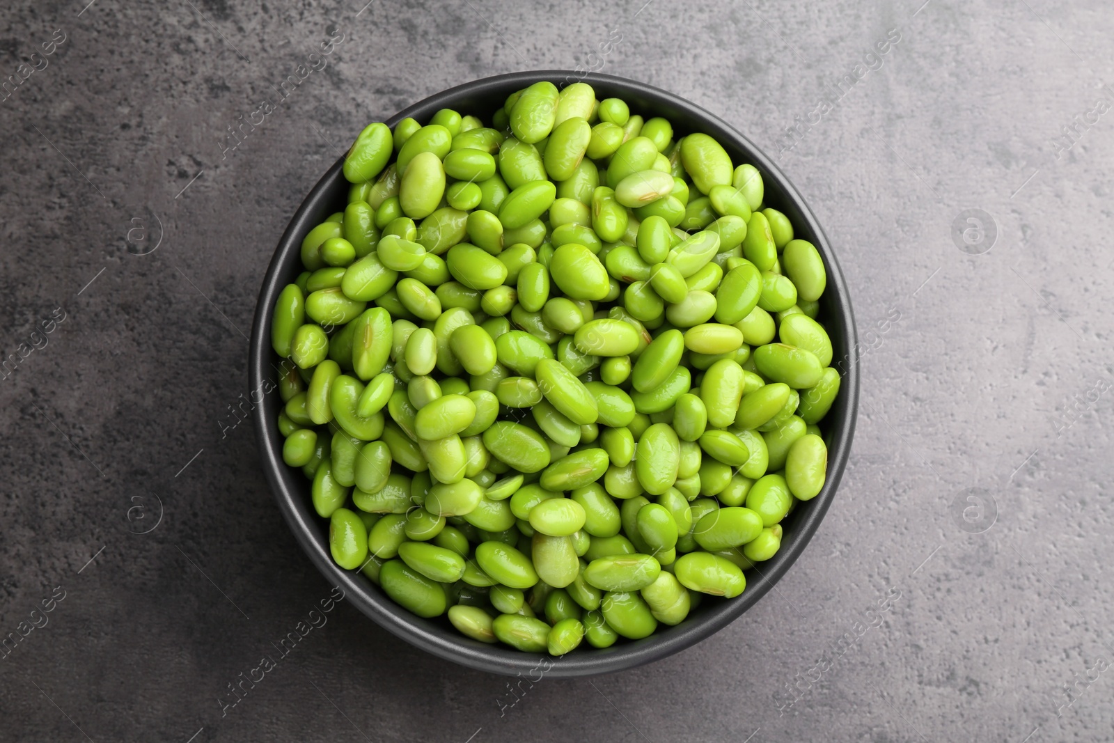 Photo of Raw green edamame soybeans on grey table, top view