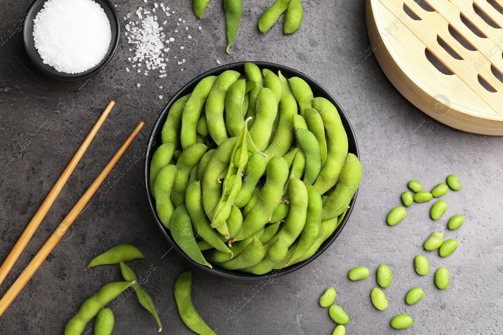 Photo of Raw green edamame soybeans and pods on grey table, flat lay