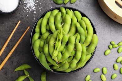 Photo of Raw green edamame soybeans and pods on grey table, flat lay