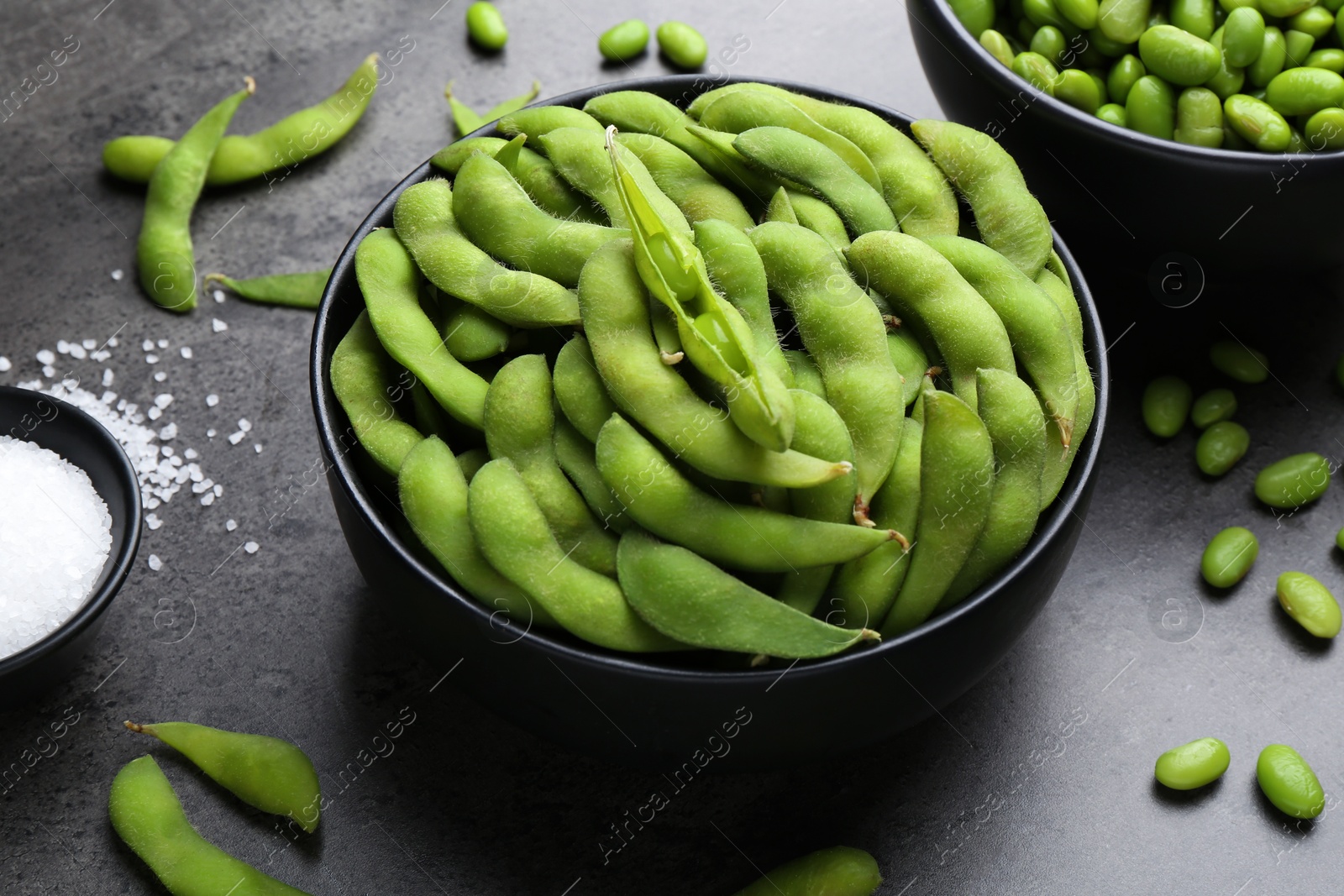 Photo of Raw green edamame soybeans and pods on grey table