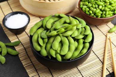 Photo of Raw green edamame soybeans and pods on grey table