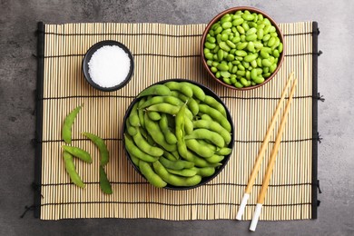 Photo of Raw green edamame soybeans and pods on grey table, top view