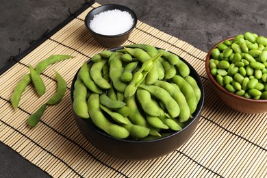 Photo of Raw green edamame soybeans and pods on grey table