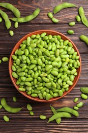 Photo of Raw green edamame soybeans and pods on wooden table, flat lay