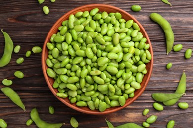 Raw green edamame soybeans and pods on wooden table, flat lay