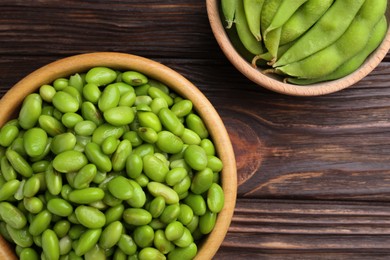 Photo of Raw green edamame soybeans and pods on wooden table, top view