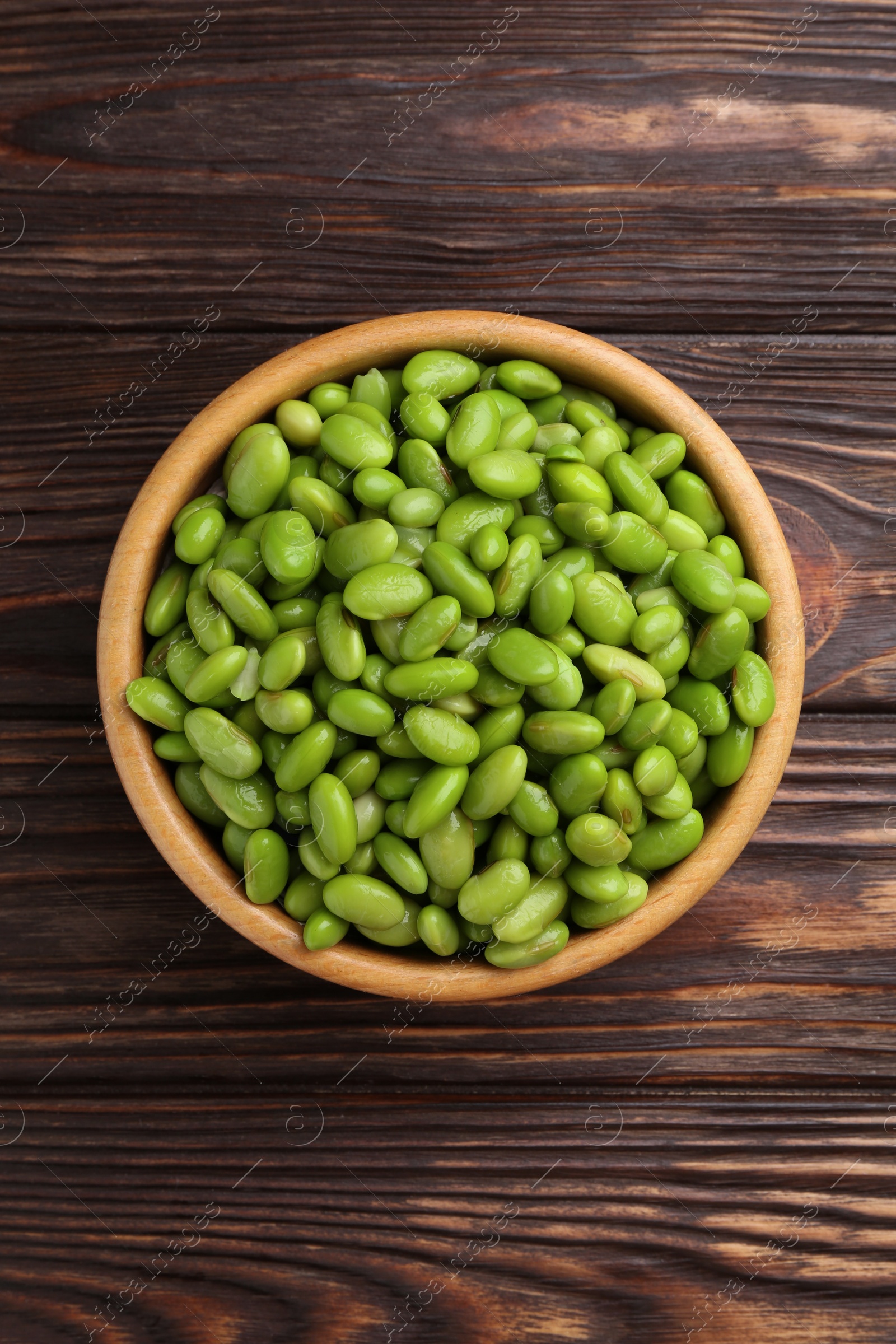 Photo of Raw green edamame soybeans on wooden table, top view