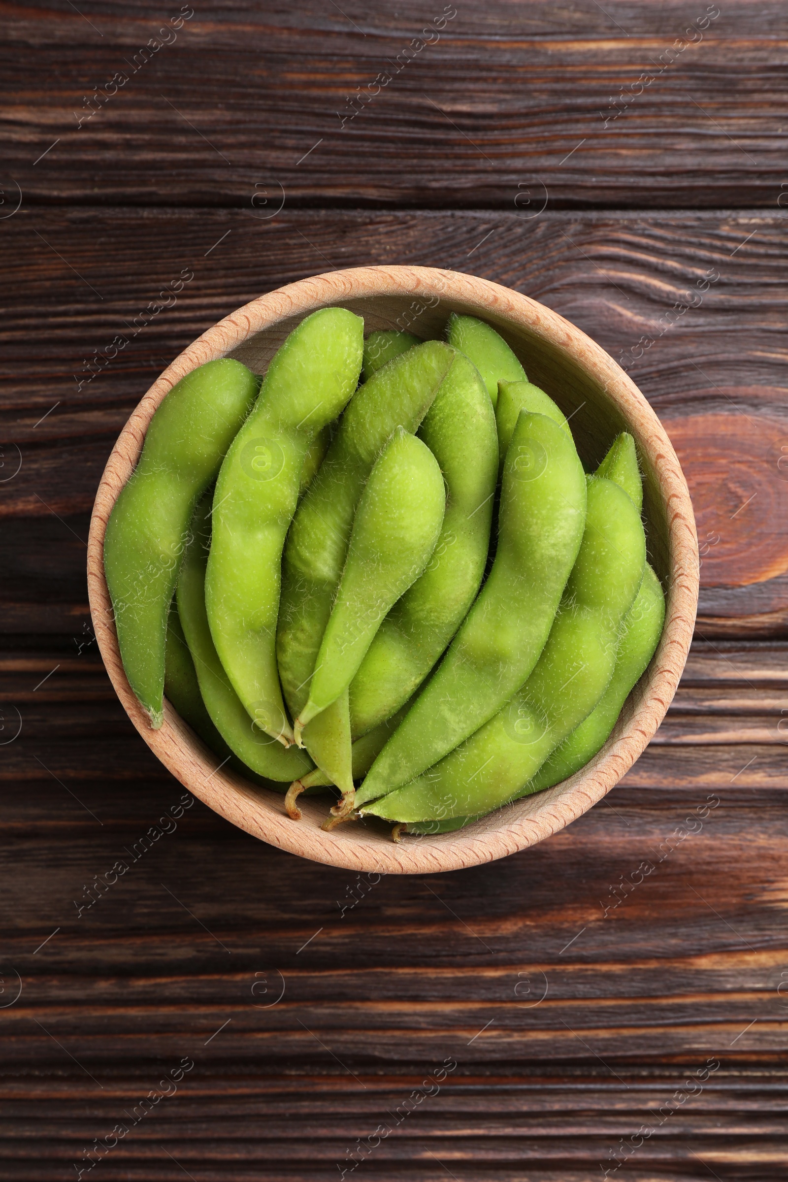 Photo of Raw green edamame pods on wooden table, top view