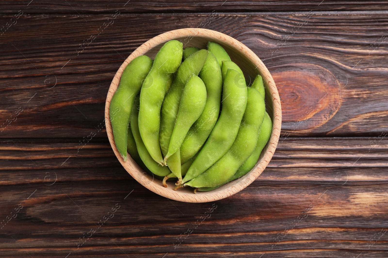 Photo of Raw green edamame pods on wooden table, top view