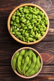 Photo of Raw green edamame soybeans and pods on wooden table, top view