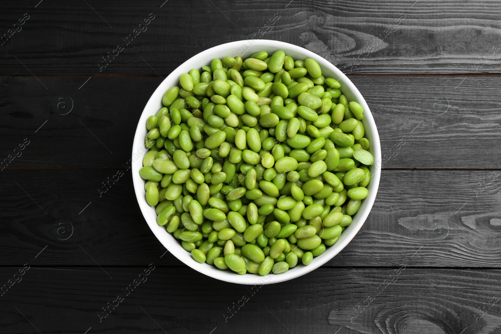 Photo of Raw green edamame soybeans on wooden table, top view