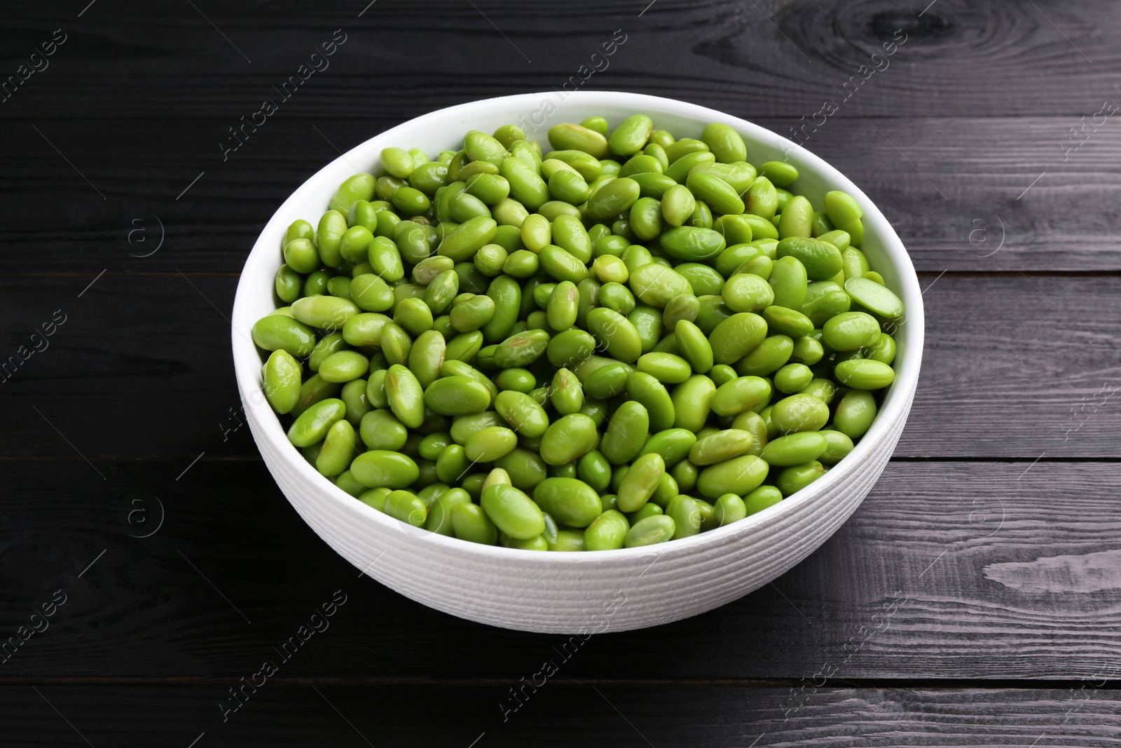 Photo of Raw green edamame soybeans on wooden table