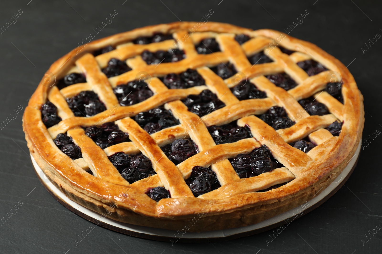 Photo of Tasty homemade pie with blueberries on grey table, closeup