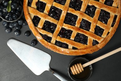 Photo of Tasty homemade pie with blueberries served on grey table, flat lay