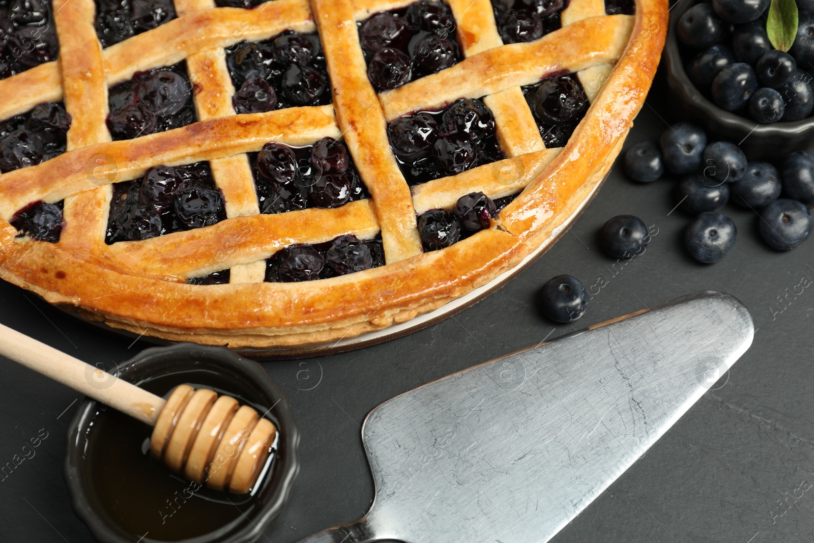 Photo of Tasty homemade pie with blueberries served on grey table, closeup