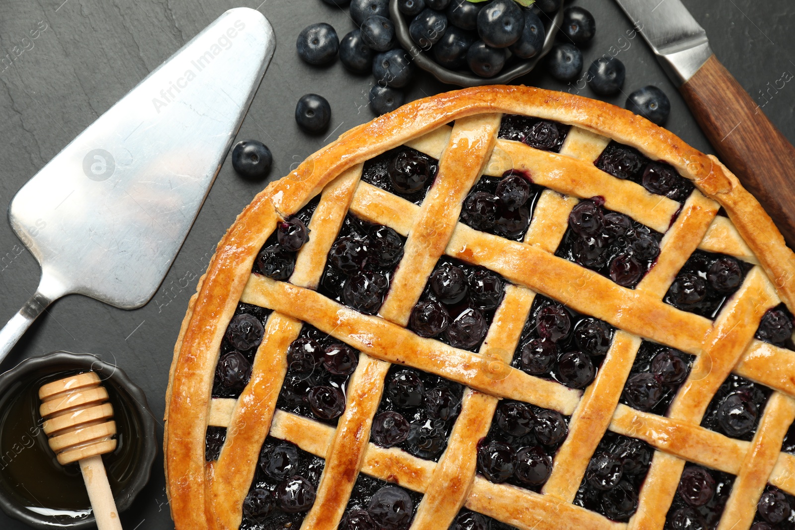 Photo of Tasty homemade pie with blueberries served on grey table, flat lay