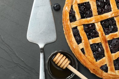 Photo of Tasty homemade pie with blueberries served on grey textured table, flat lay