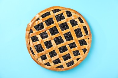 Photo of Tasty homemade pie with blueberries on light blue table, top view