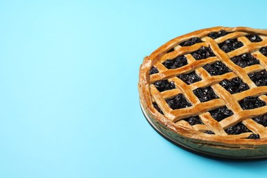 Photo of Tasty homemade pie with blueberries on light blue table. Space for text