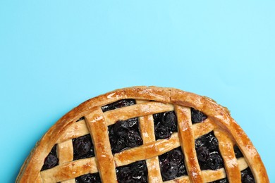 Photo of Tasty homemade pie with blueberries on light blue table, top view. Space for text