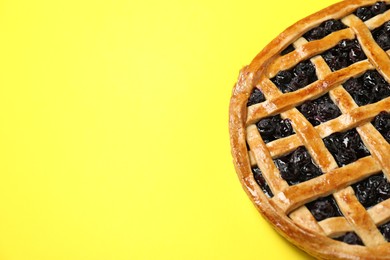 Tasty homemade pie with blueberries on yellow table, closeup. Space for text