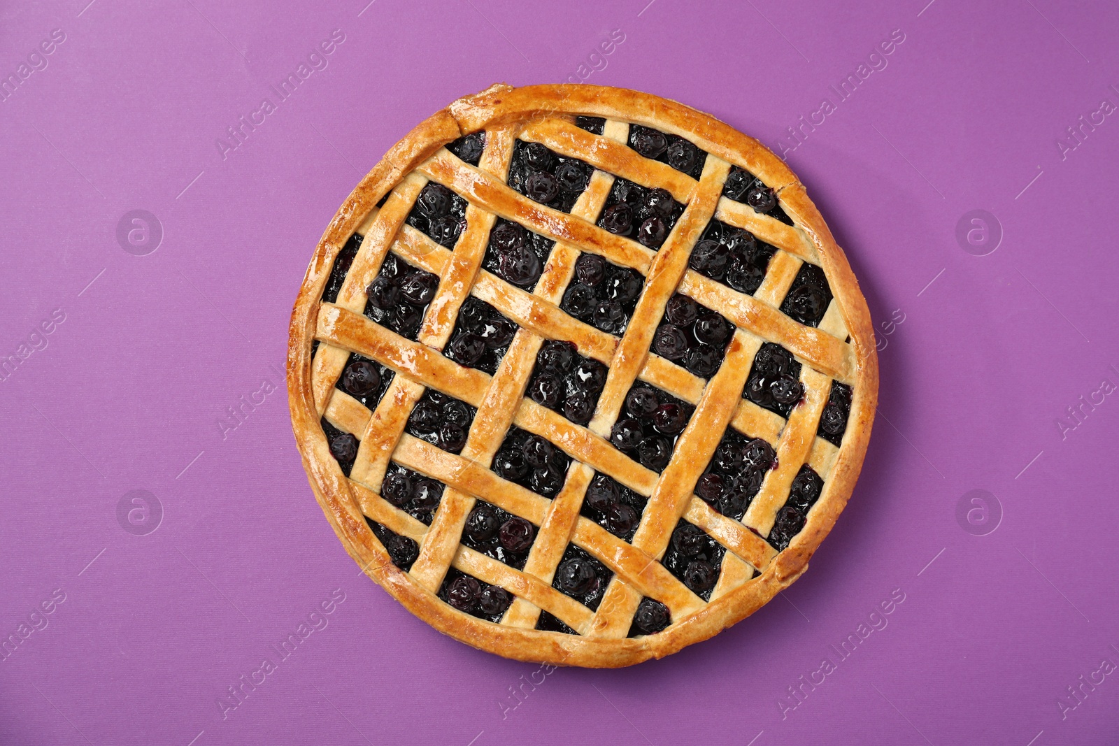 Photo of Tasty homemade pie with blueberries on purple table, top view