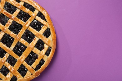 Photo of Tasty homemade pie with blueberries on purple table, top view. Space for text