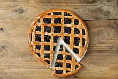 Photo of Tasty homemade pie with blueberries on wooden table, top view