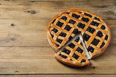 Photo of Tasty homemade pie with blueberries on wooden table. Space for text