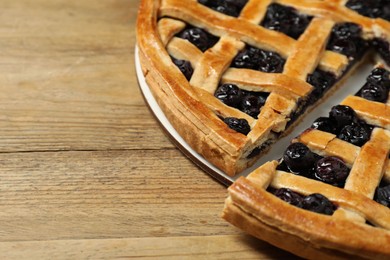 Photo of Tasty homemade pie with blueberries on wooden table, closeup. Space for text